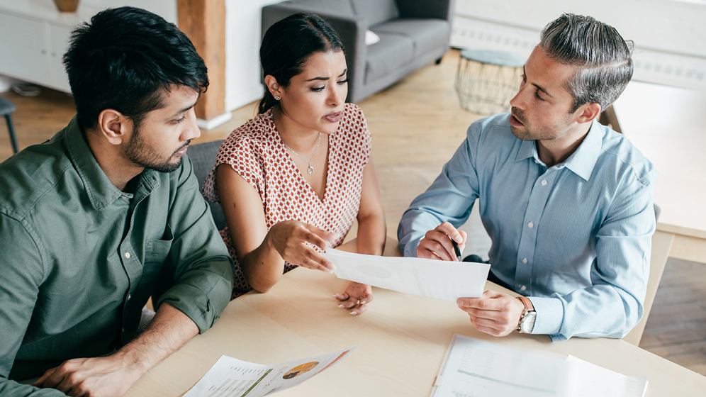 An advisor shares paperwork with his clients. 