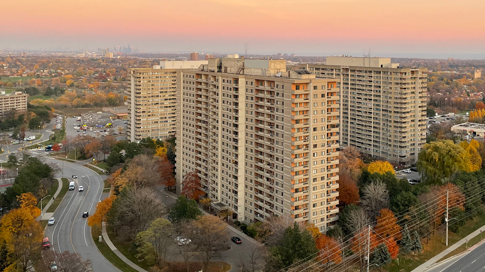 Aerial view of cityscape during autumn, with mid-rise condominium towers. 