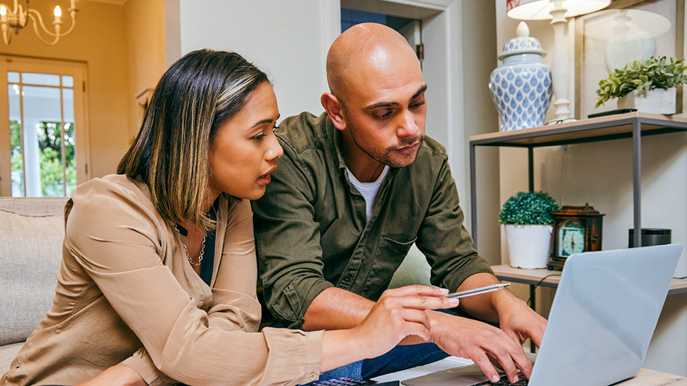 A couple works together on their laptop. 