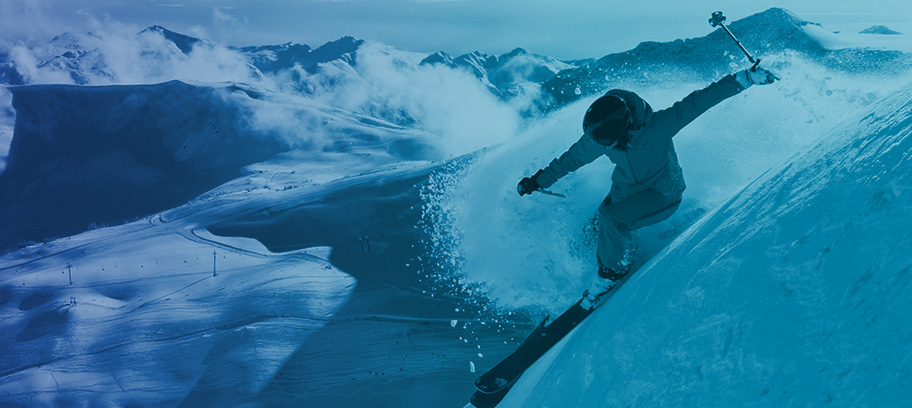 Person skiing at the top of a snow-covered mountain.