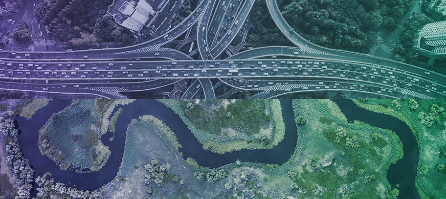 Aerial view of busy highway system combined with winding river. 